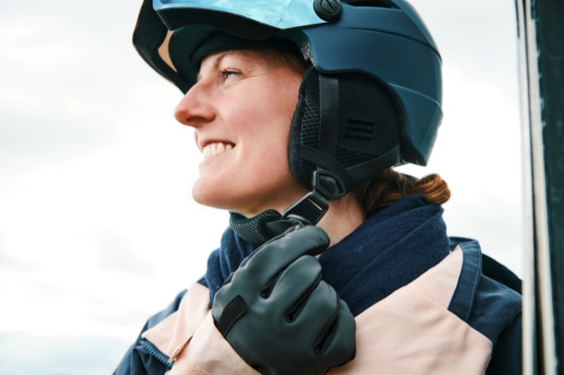 Woman with Ski Helmet opening buckle