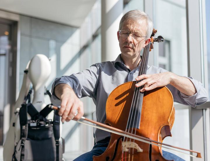 Joachim Fielder playing cello in the staircase of the FIDLOCK Headquarters in Hannover